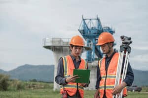survey team is operating a leveling instrument during the construction of an elevated high-speed railway. The scene emphasizes precision engineering, modern infrastructure development, and the progress of advanced transportation systems.